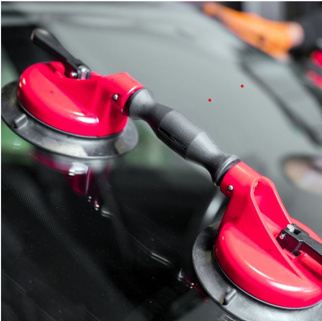 Close-up of two red suction cups attached to a glass surface.