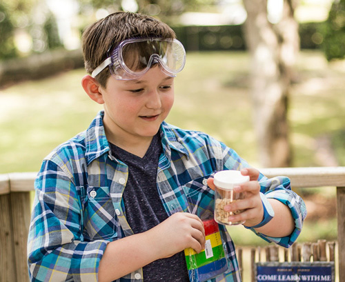 boy learning and making experiments outside