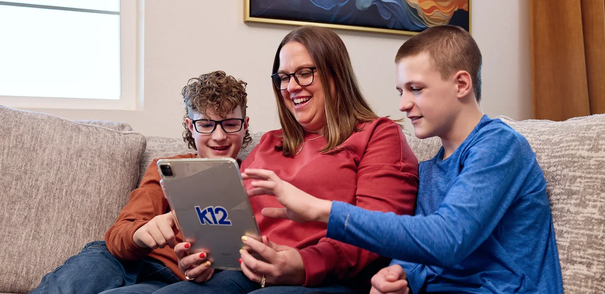 students looking the iPad and smiling